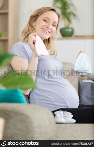 pregnant woman is holding baby hat
