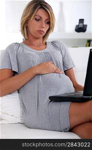 Pregnant woman looking at a laptop