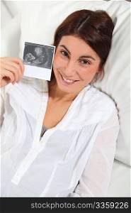 Pregnant woman looking at sonogram of future child
