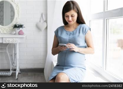 pregnant woman looking her phone