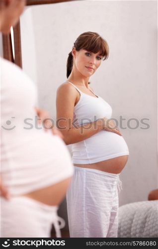 Pregnant woman looking in mirror
