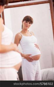 Pregnant woman looking in mirror