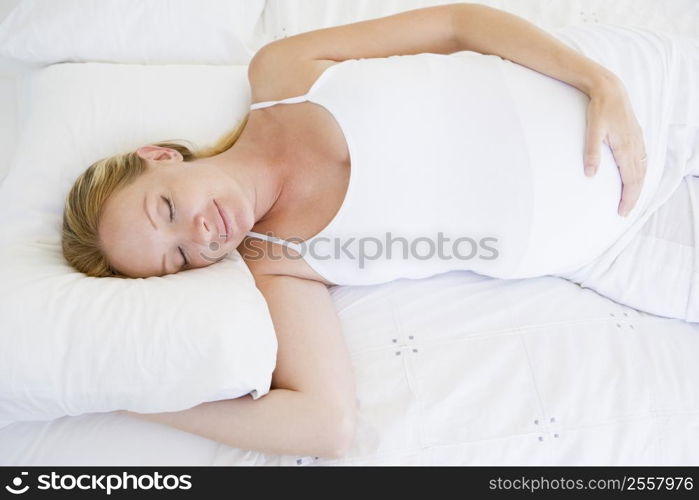 Pregnant woman lying in bed sleeping