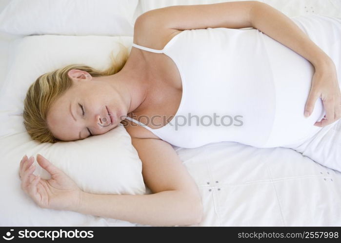 Pregnant woman lying in bed sleeping