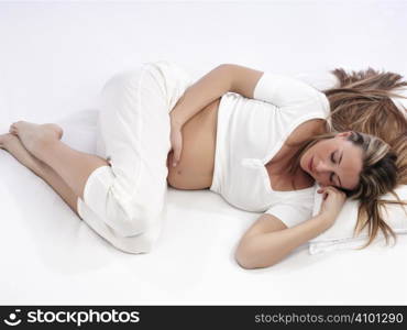 Pregnant woman lying in bed sleeping