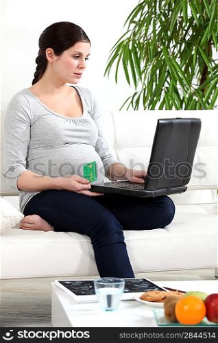 Pregnant woman making a payment online