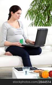 Pregnant woman making a payment online