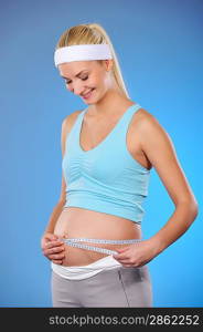 Pregnant woman measures her belly