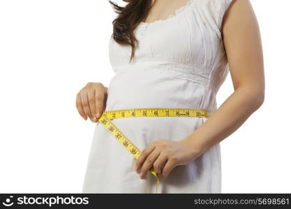 Pregnant woman measuring her belly