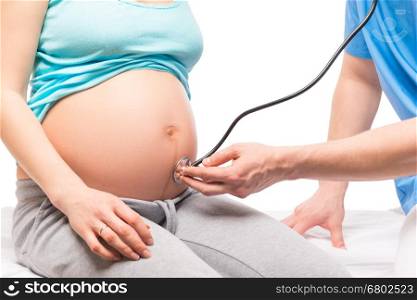 Pregnant woman on reception at the gynecologist, belly closeup