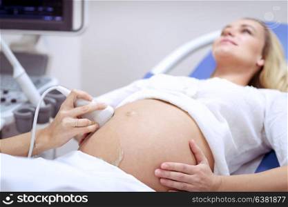 Pregnant woman on ultrasound, responsible mother checking health of her baby in the belly, health care on third trimester, sonography in the good maternity hospital