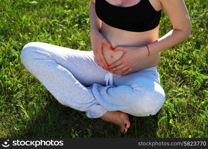 Pregnant woman outdoors at sunny summer day