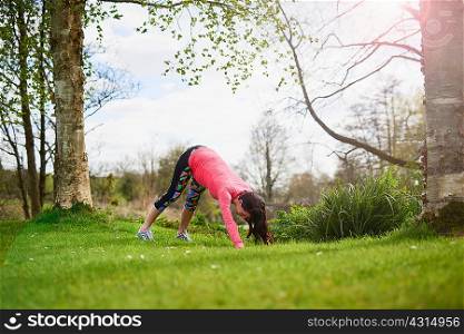 Pregnant woman outdoors, in yoga position