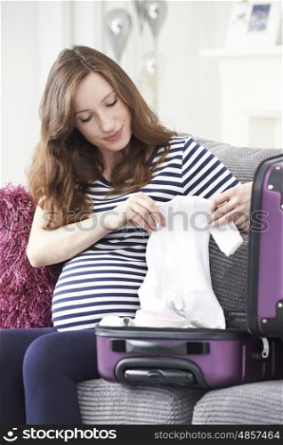 Pregnant Woman Packing Suitcase For Trip To Hospital