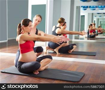 pregnant woman pilates exercise workout at gym with personal trainer