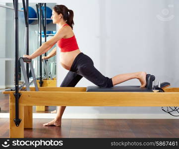 pregnant woman pilates reformer cadillac exercise workout at gym