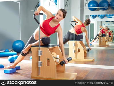 pregnant woman pilates side stretch exercise on wunda chair at gym indoor