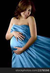 Pregnant woman posing on a black background with beautiful dress