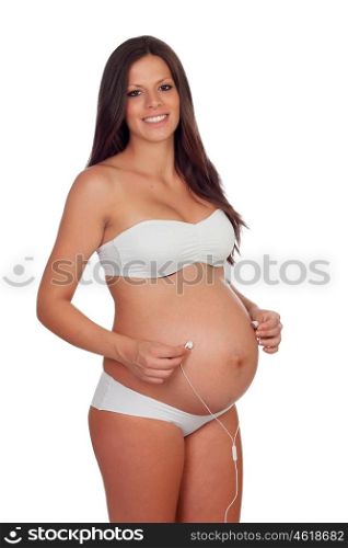 Pregnant woman putting headphones on her belly isolated on a white background