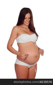 Pregnant woman putting headphones on her belly isolated on a white background