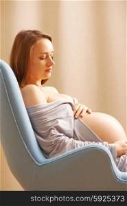 Pregnant woman relaxing at home in chair