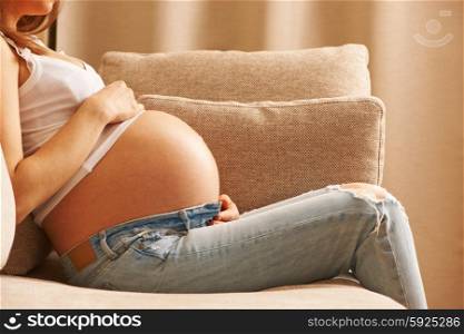 Pregnant woman relaxing at home on couch