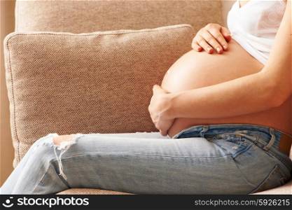 Pregnant woman relaxing at home on couch