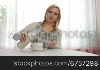 Pregnant Woman relaxing with Cup of Tea, Pouring milk