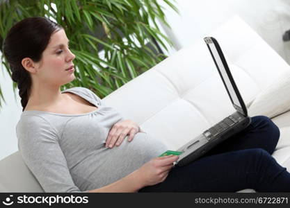 Pregnant woman sat on sofa