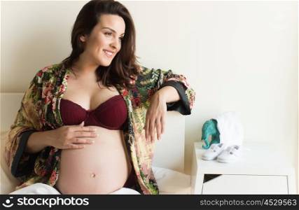 Pregnant woman showing her 39 weeks belly at home