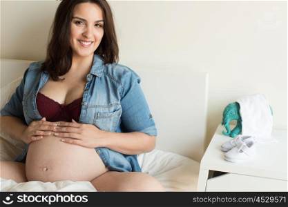 Pregnant woman showing her 39 weeks belly at home