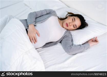 pregnant woman sleeping on a bed