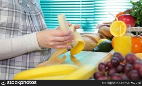 Pregnant woman sliced banana in the kitchen
