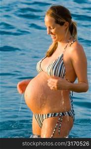 Pregnant Woman Splashing Water on Belly