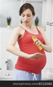 Pregnant Woman Spraying Mosquito Repellant To Protect Against Zika Virus
