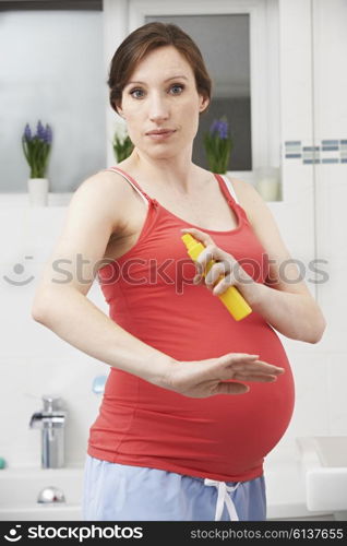 Pregnant Woman Spraying Mosquito Repellant To Protect Against Zika Virus