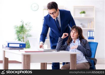 Pregnant woman struggling in the office and getting colleague he. Pregnant woman struggling in the office and getting colleague help. Pregnant woman struggling in the office and getting colleague he