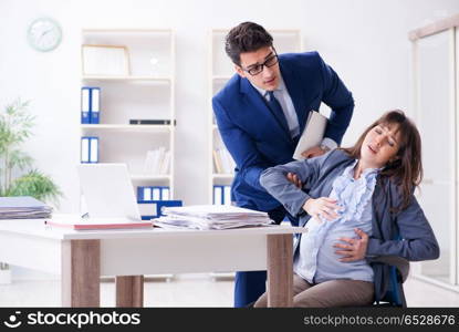 Pregnant woman struggling in the office and getting colleague he. Pregnant woman struggling in the office and getting colleague help. Pregnant woman struggling in the office and getting colleague he