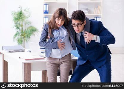 Pregnant woman struggling in the office and getting colleague help. Pregnant woman struggling in the office and getting colleague he