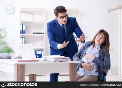 Pregnant woman struggling in the office and getting colleague help. Pregnant woman struggling in the office and getting colleague he