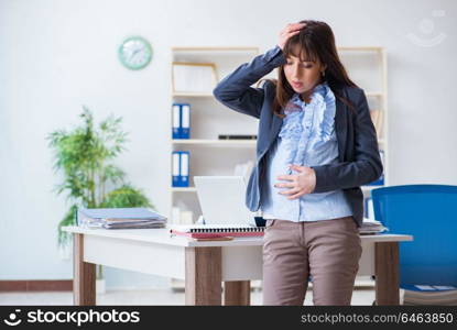 Pregnant woman struggling to do work in office