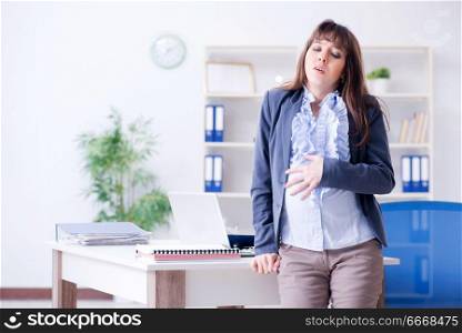 Pregnant woman struggling to do work in office