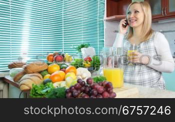 Pregnant woman talking on her mobile phone and drink orange juice in the kitchen