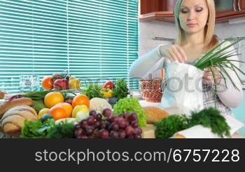 Pregnant woman Unloading Groceries from the Bag in the kitchen