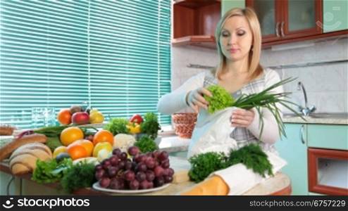 Pregnant woman Unloading Groceries from the Bag in the kitchen