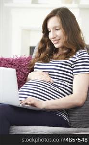 Pregnant Woman Using Laptop At Home