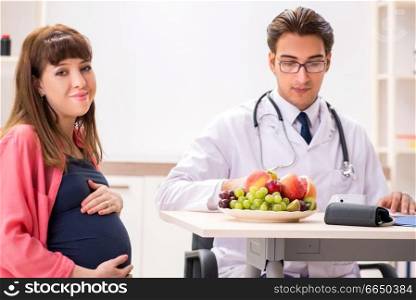 Pregnant woman visiting doctor discussing healthy diet