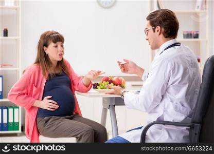 Pregnant woman visiting doctor discussing healthy diet