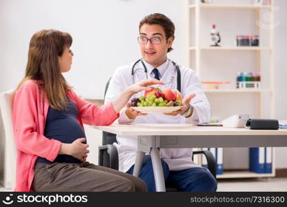 Pregnant woman visiting doctor discussing healthy diet