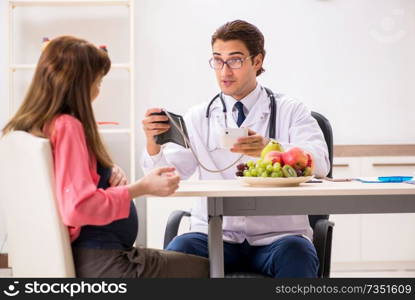 Pregnant woman visiting doctor discussing healthy diet